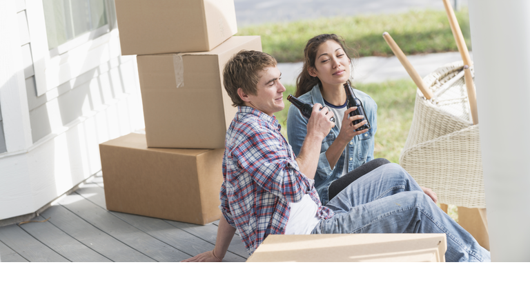 Young couple moving, taking a break, drinking
