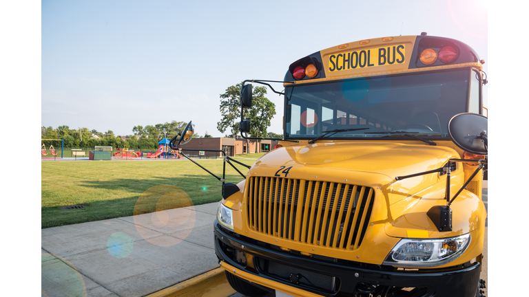 Yellow school bus parked next to playground