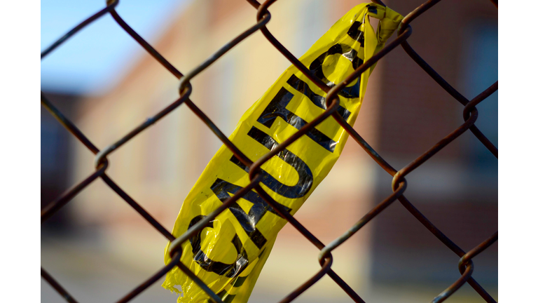Caution tape tied to a chain link fence outside of an elementary school in Winnipeg, Manitoba, Canada