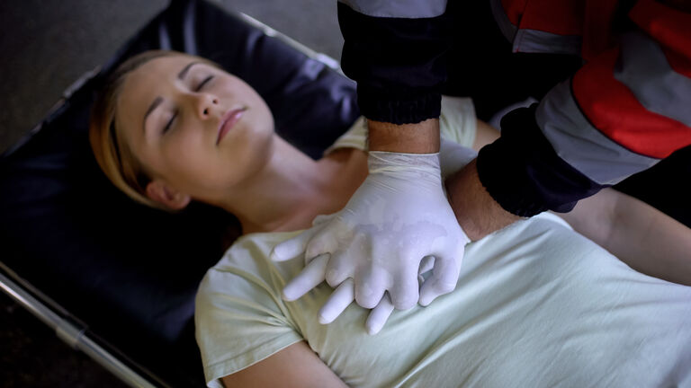 Doctor doing CPR to woman, patient death, mortality from road traffic accidents