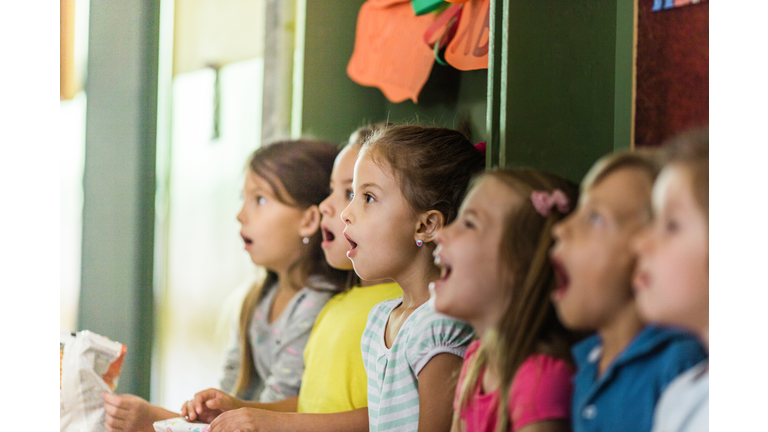 Group of elementary students singing in choir at school.