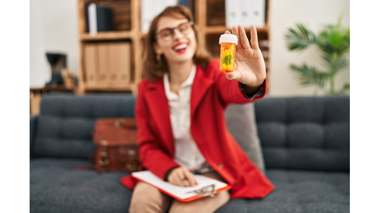 Young caucasian woman psychologist prescribe pills treatment at psychology center