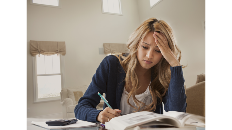 Anxious mixed race woman studying