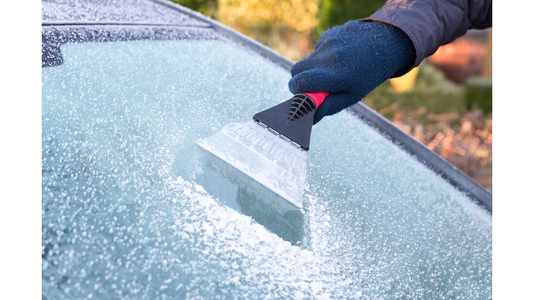 Hand scratching ice from car window