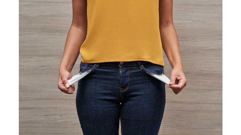 Unrecognizable young women showing her empty pockets without money.