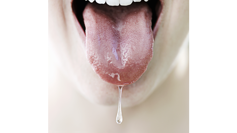 Woman's tongue dripping with saliva, close-up