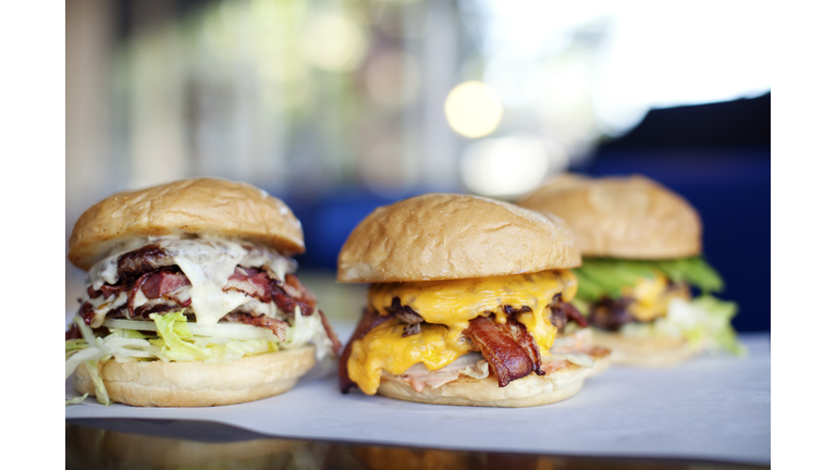 Various indulgent cheeseburgers in diner