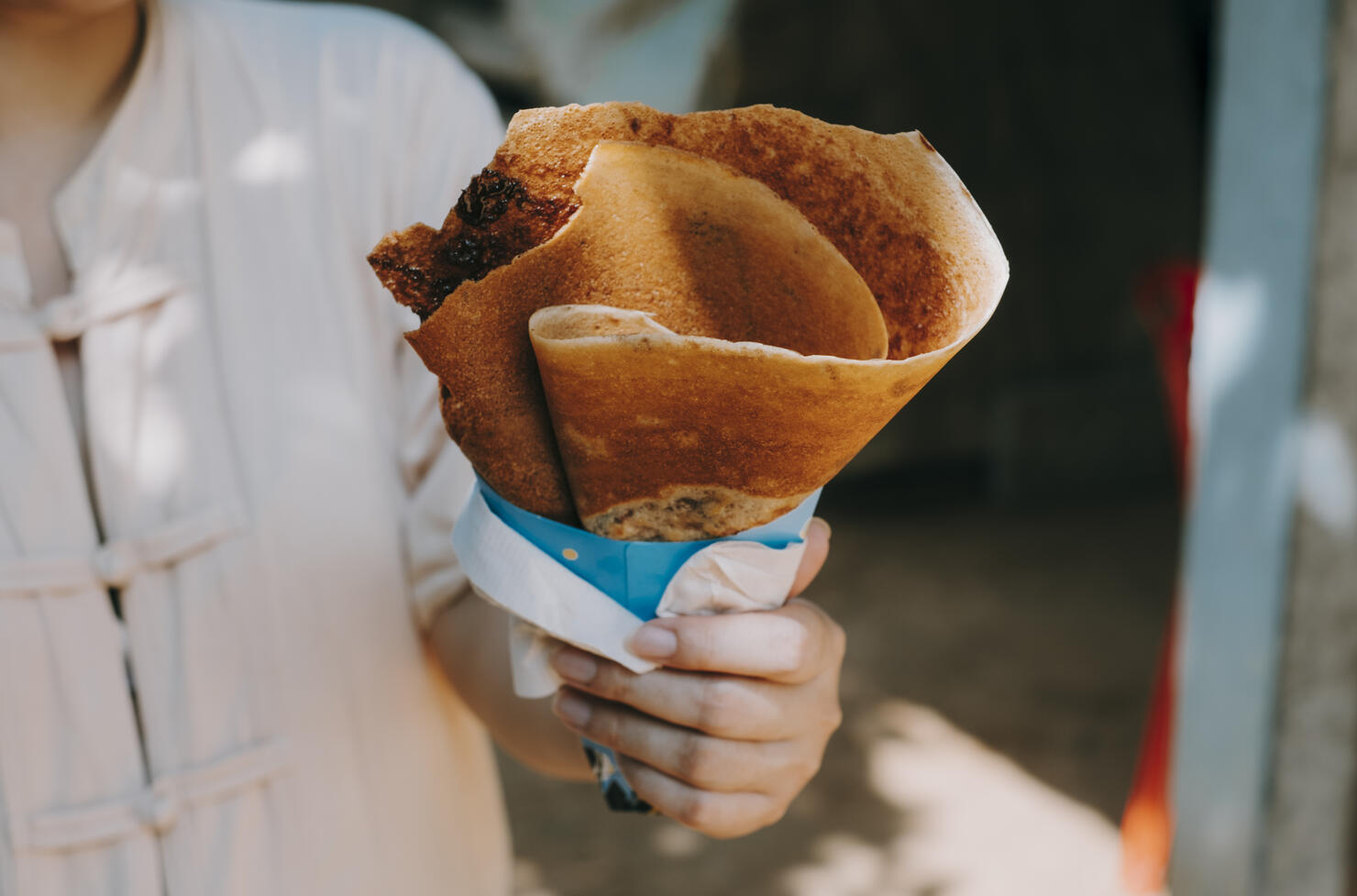 Close-Up Of Hand Holding Cheese Crepe