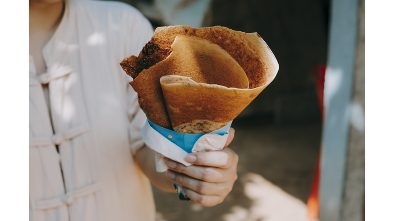 Close-Up Of Hand Holding Cheese Crepe