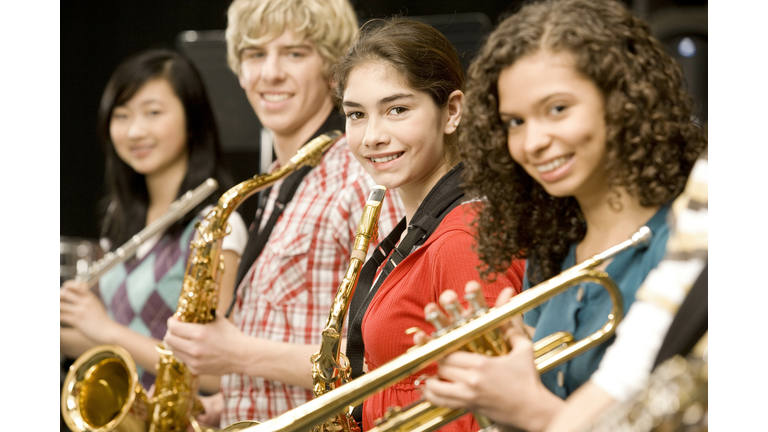 Teenage girl playing saxophone in band