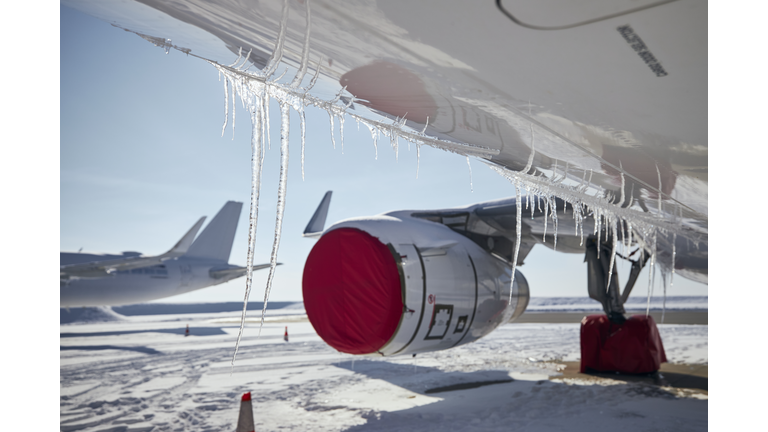 Selective Focus On Icicles From Airplane In Frosty Day. Grounded Planes At Snowy Airport.