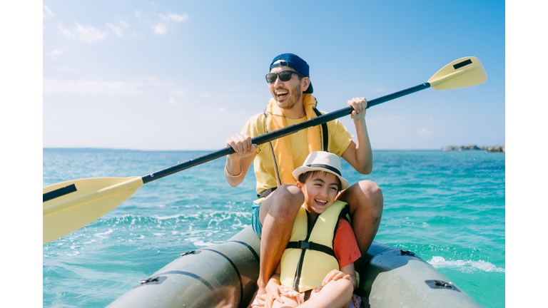 Father and young daughter enjoying sea kayaking on tropical sea