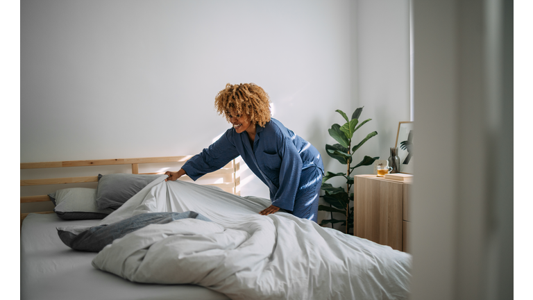 Beautiful Woman Making her Bed in the Morning