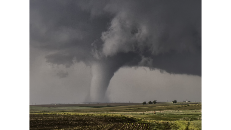 A large cone tornado touches down over the open prairie