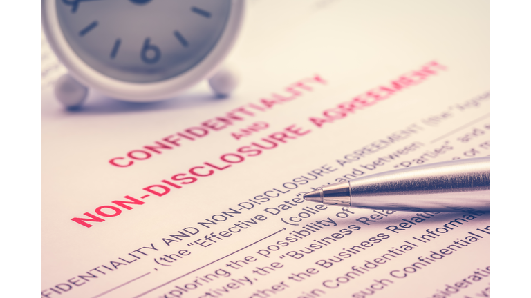 Confidentiality and non-disclosure agreement form and a pen, business legal document concept. Confidentiality agreement is legal contract between two parties that outlines confidential issues together