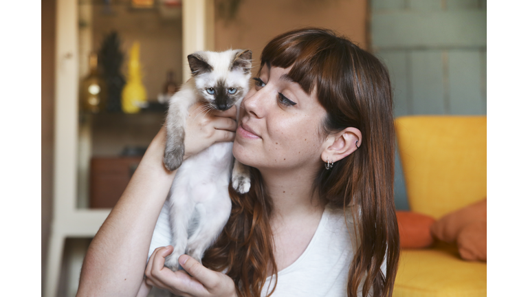 Young woman with kitten at home