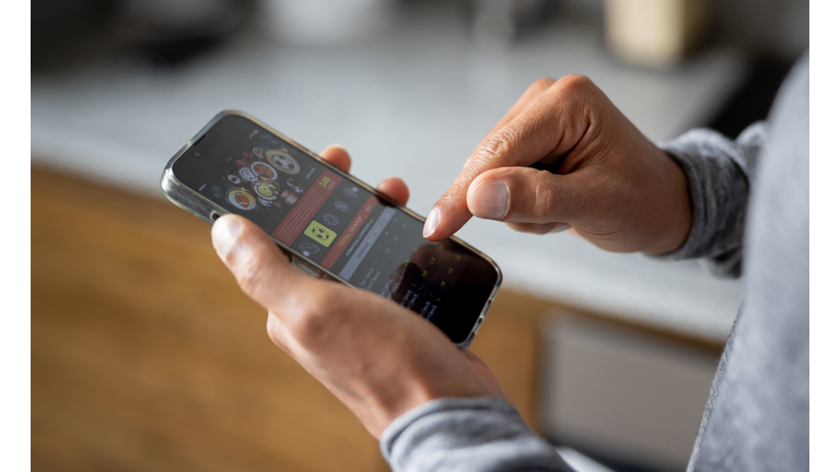 Close-up on a man betting online on a sports app in his cell phone