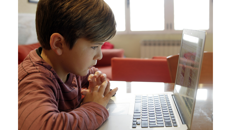 Boy using laptop for homework or homeschooling