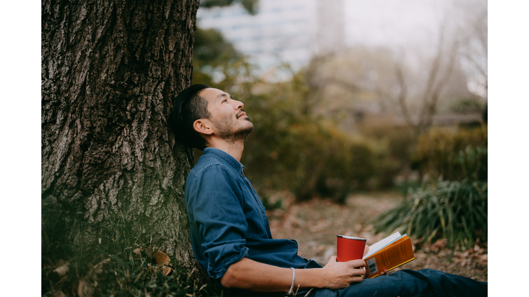 Man having a coffee break at park in city, Tokyo