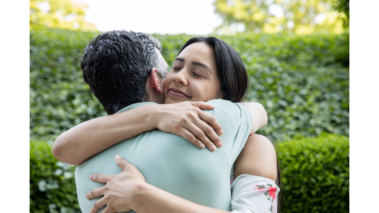 Mature couple give hugs while greeting each other