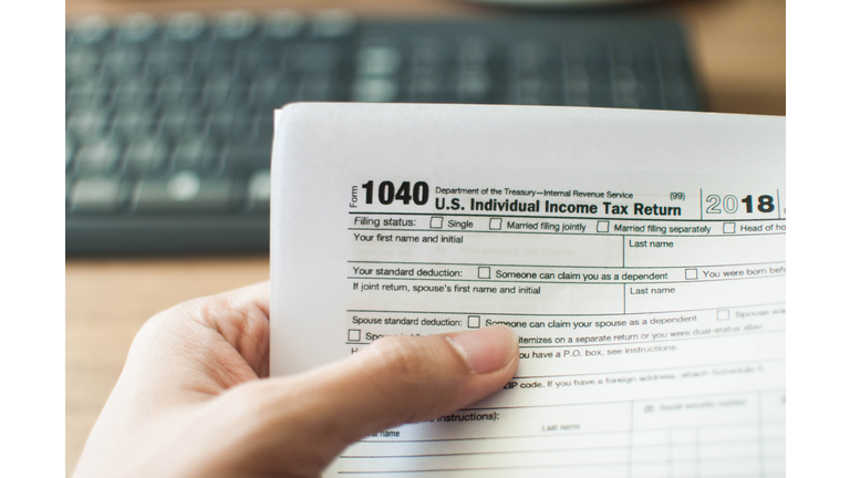 A young man holding a tax form