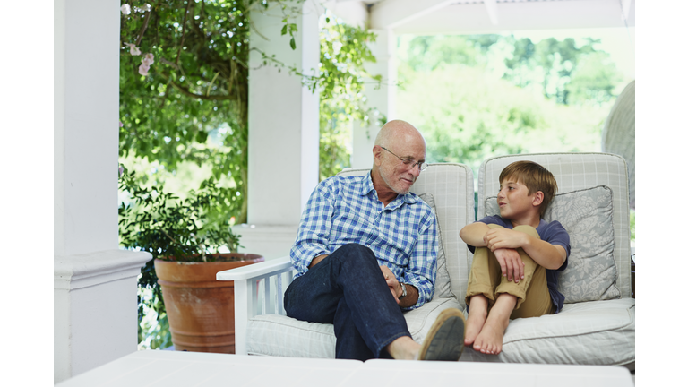 Boy communicating with grandfather at porch