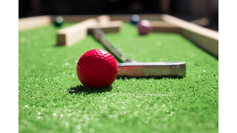 Red ball and metal club on the mini golf course,Ukraine