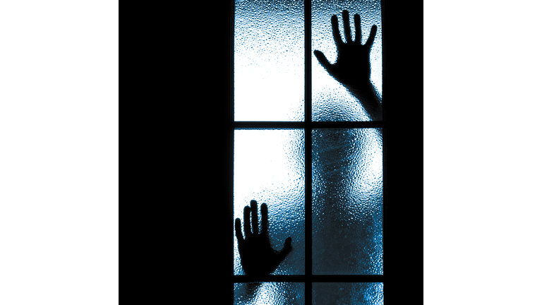 Scared boy behind glass door