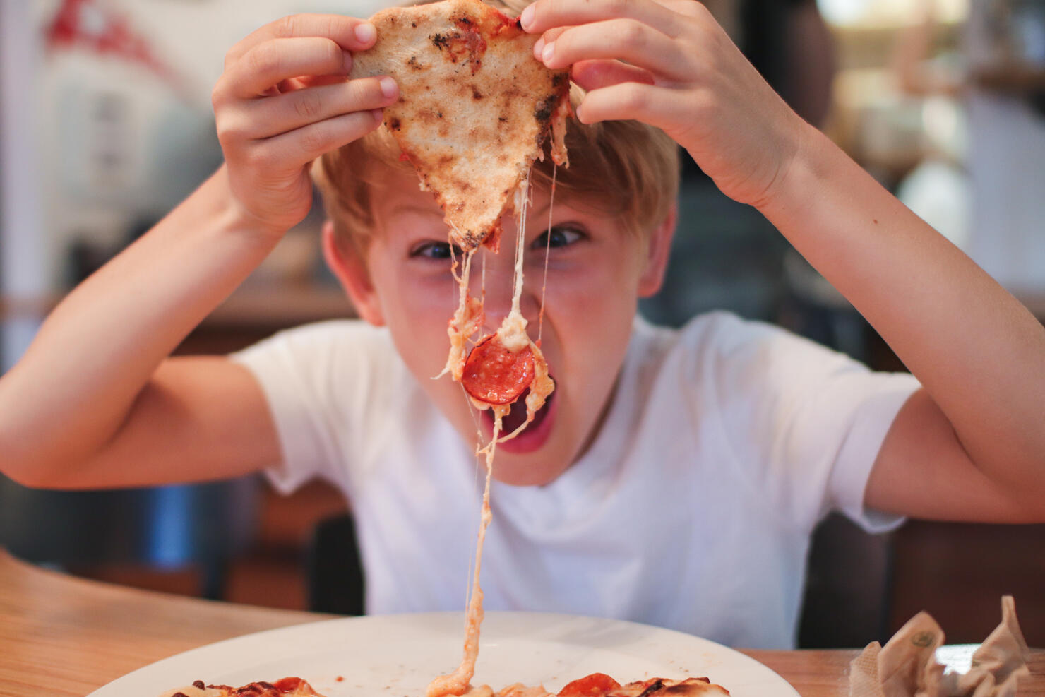 Portrait Of Boy Eating Pepperoni Pizza