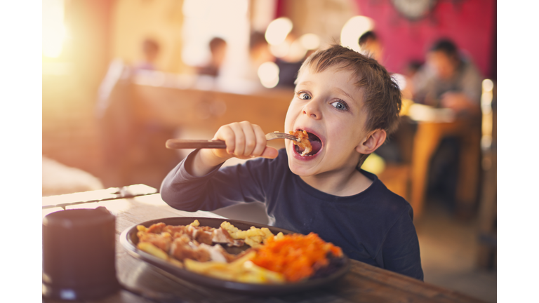 Little boy enjoying dinner at the restaurant