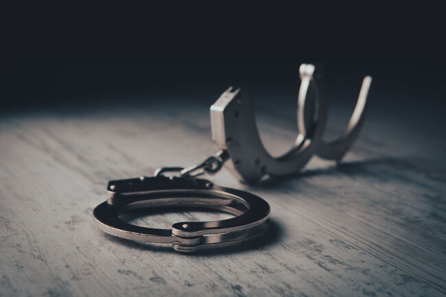 closeup of handcuffs on obscure stainless steel