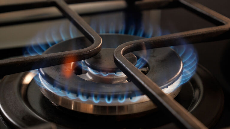 Kitchen stove through which gas comes out converted into blue and orange flame. Concept of gas, crisis, economy, war, supply, natural gas, prices and Russia.