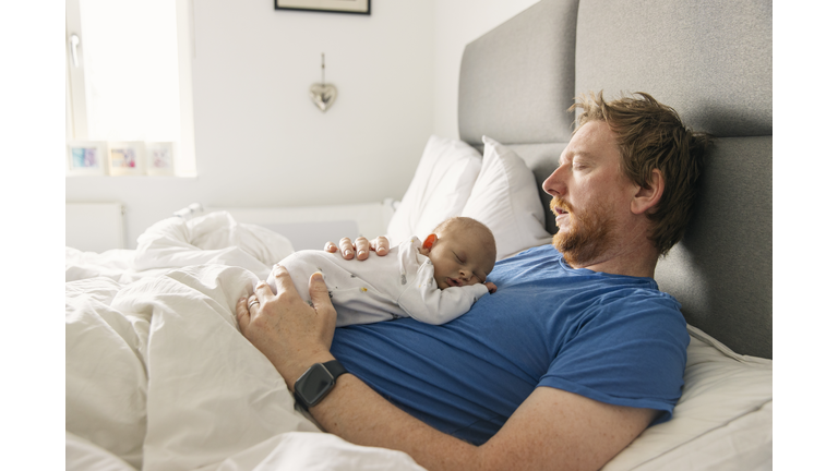 Newborn baby asleep on father's chest