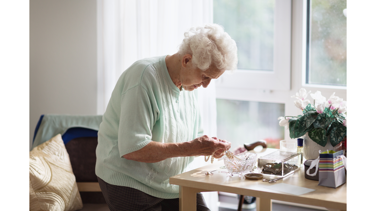 Alzheimers disease: senior woman sorting her jewelry