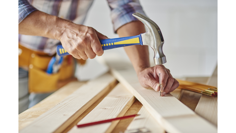 Carpenter with hammer hitting nails