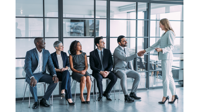 HR manager handshaking with candidate at job interview.