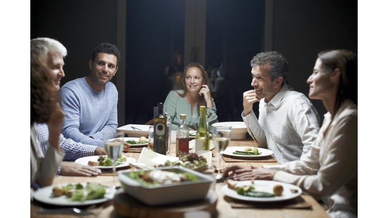 Friends communicating while having dinner at table