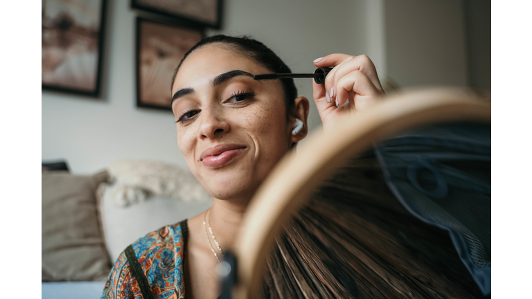 Beautiful woman using mascara.