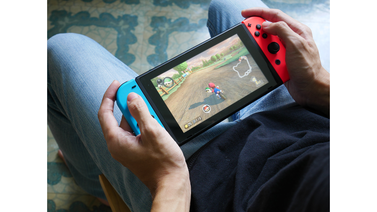 Bangkok, Thailand - June 25, 2017 : A man playing Mario Kart 8 Deluxe on Nintendo Switch.