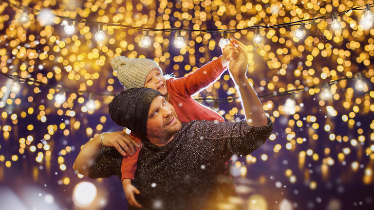 father and daughter decorate outside for christmas. family party.