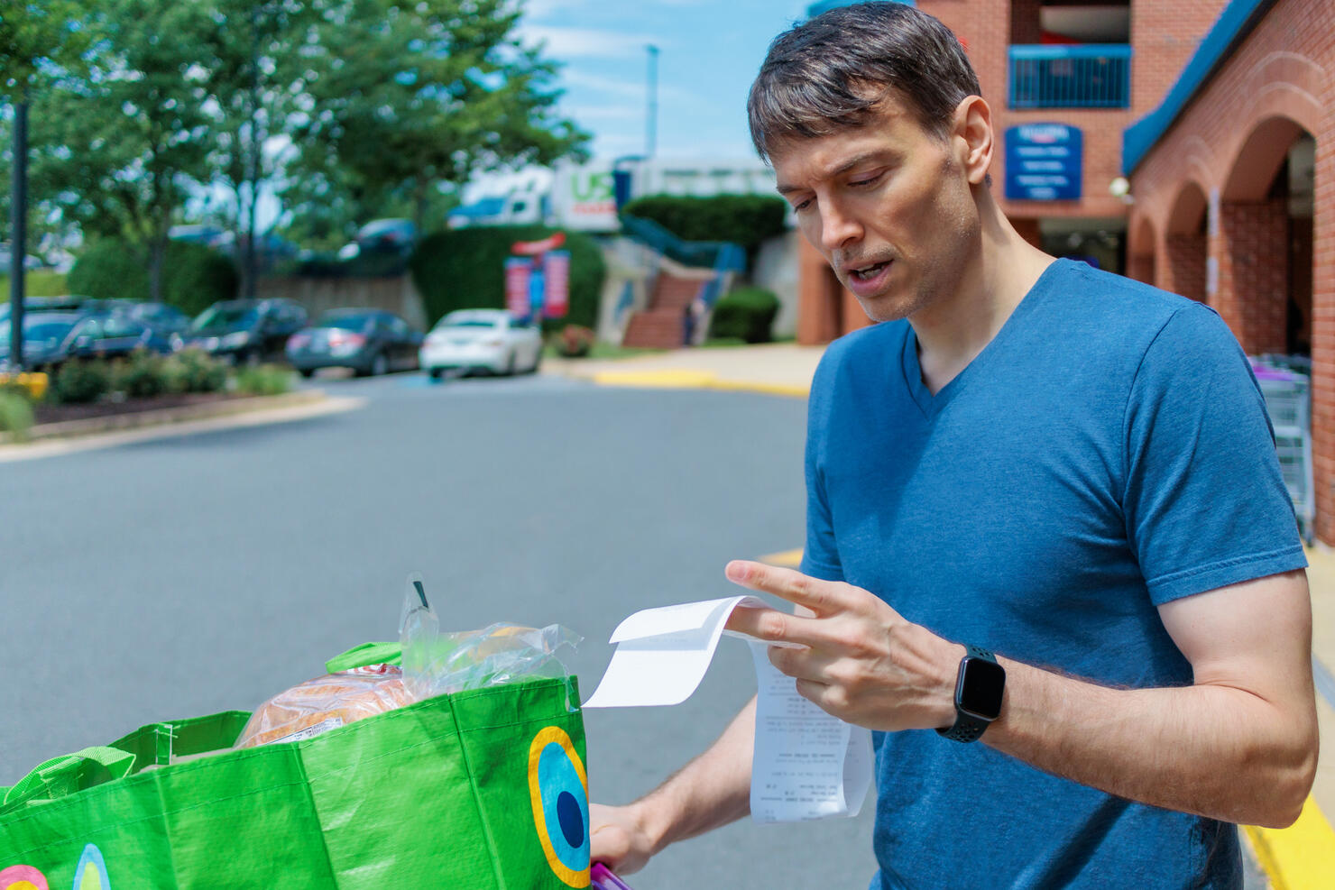 Man Checks Receipt Upon Leaving Supermarket
