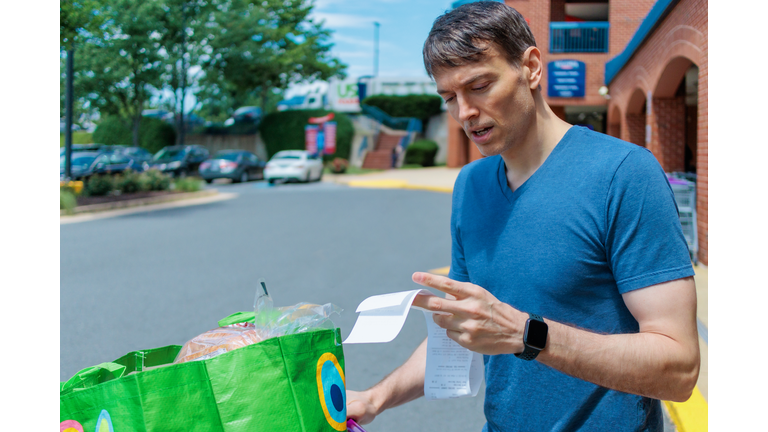 Man Checks Receipt Upon Leaving Supermarket