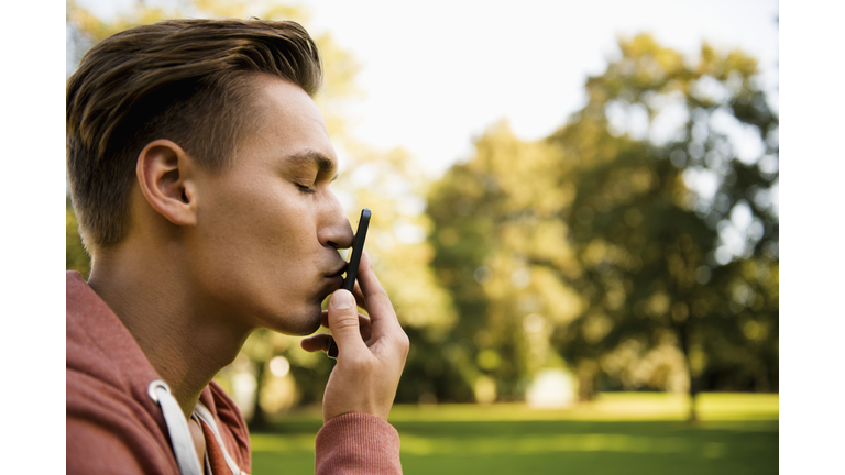 Young man kissing his smart phone, close-up