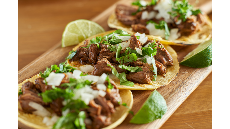 three carne asada mexican street tacos in corn tortilla with lime