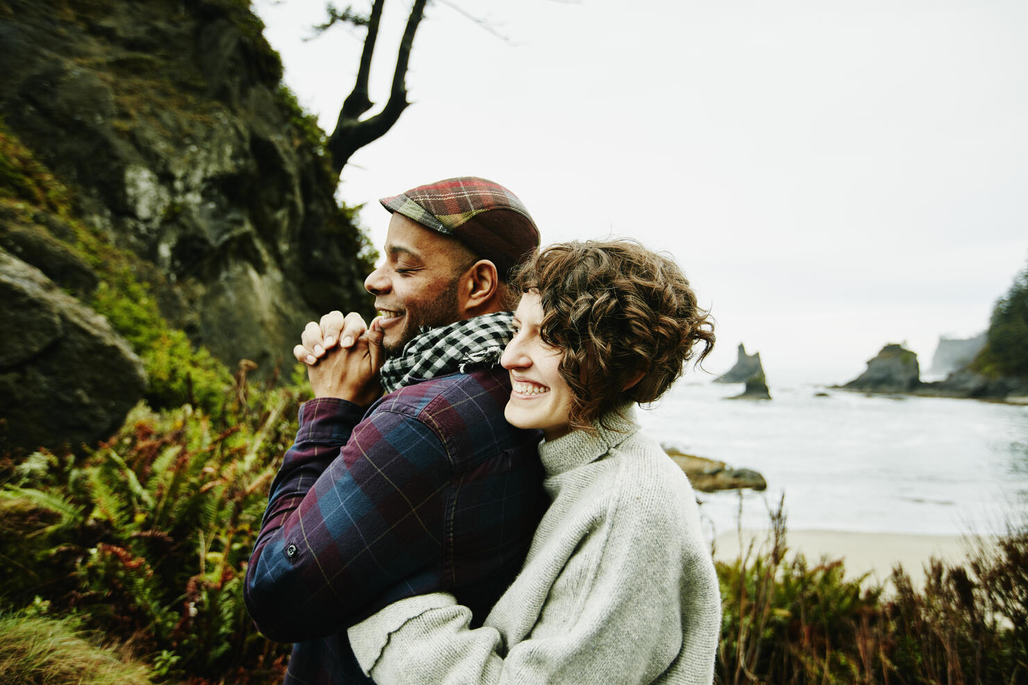 Laughing couple embracing at beach overlook