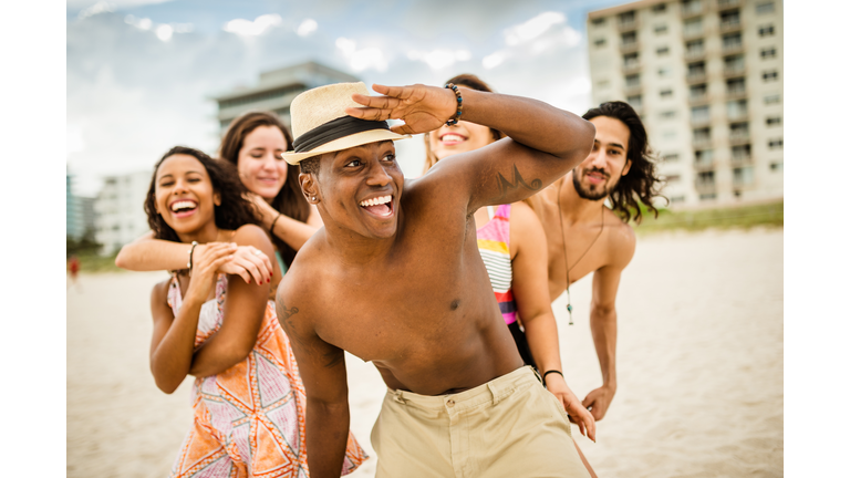friends dancing on the beach for a party