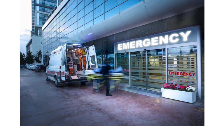 Paramedics taking patient on stretcher from ambulance to hospital