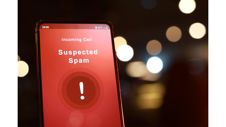 Suspected spam call from an unknown caller shown a smartphone display screen against illuminated light background