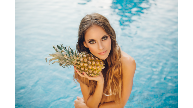 Beautiful woman by swimming pool.