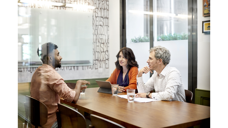 Colleagues discussing in meeting at office